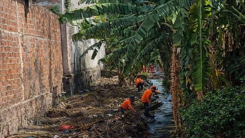 homens fazendo a limpeza de um canal